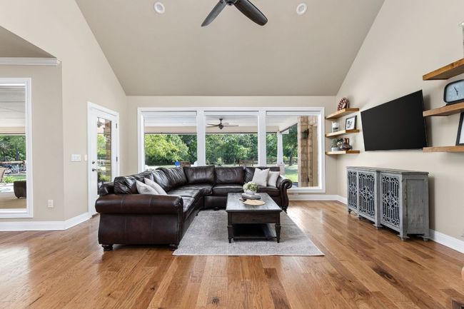 The bright and airy living room features large windows that frame tranquil Hill Country views. | Image 6