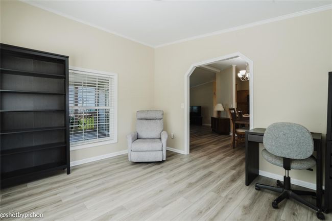 Office featuring a chandelier, light wood-type flooring, ornamental molding, and arched walkways | Image 7
