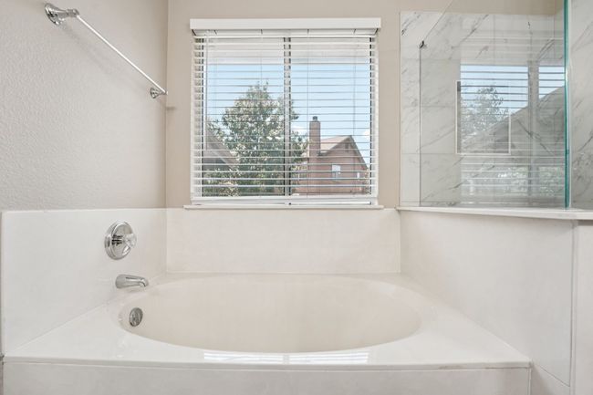 Full bath featuring a bath and a marble finish shower | Image 21