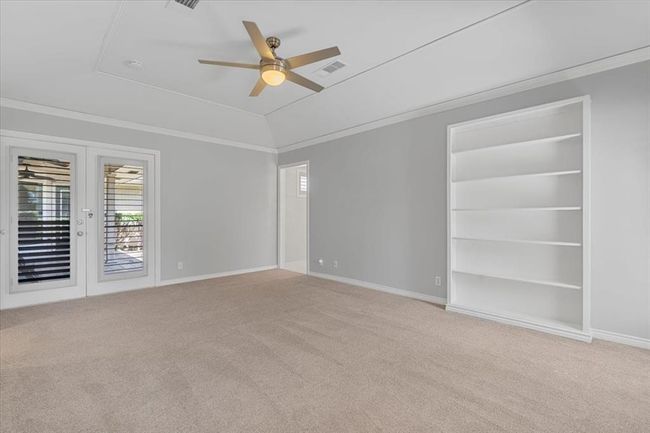 Spare room featuring vaulted ceiling, carpet floors, french doors, crown molding, and ceiling fan | Image 11