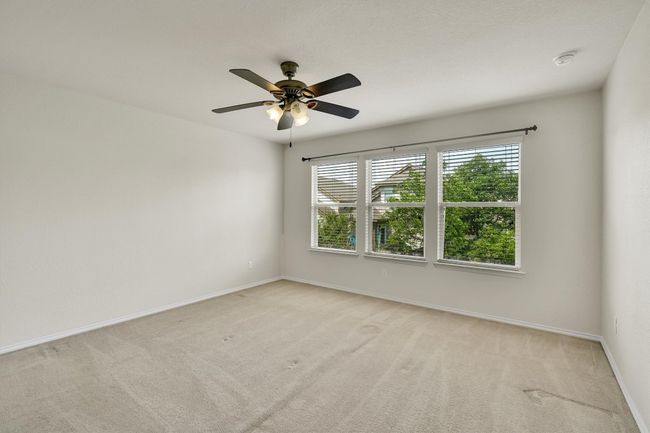 Empty room with light carpet, a ceiling fan, and baseboards | Image 22