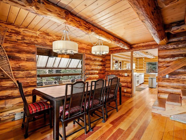 Dining space featuring beam ceiling, wooden ceiling, log walls, and hardwood / wood-style flooring | Image 11