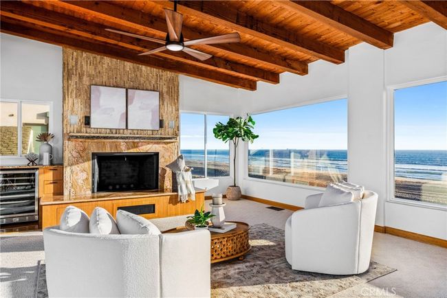 Including a sitting area with a fireplace surrounded by stacked stone and a mantle. | Image 34