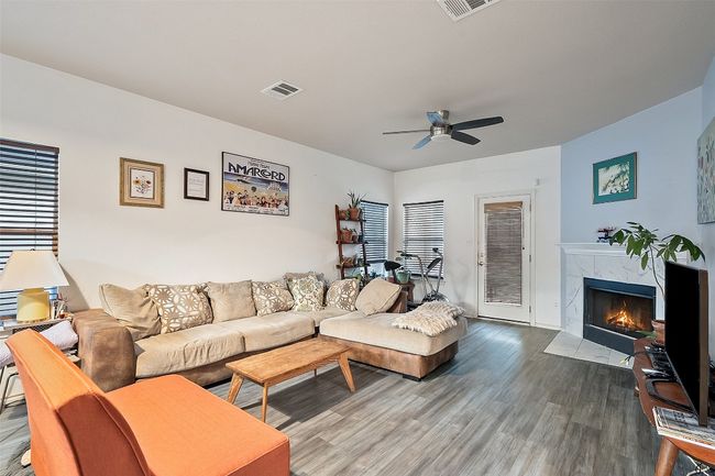 A large archway from the kitchen overlooks the dining and living with a corner fireplace with tile surround.Recent upgrades include vinyl plank flooring, water heater, range, roof and HVAC. | Image 15