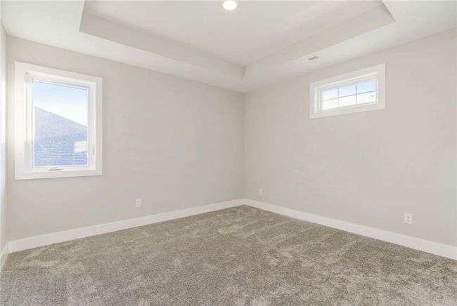 Carpeted empty room featuring a tray ceiling and baseboards | Image 19