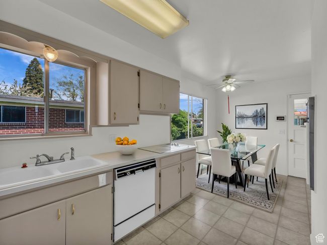 Kitchen featuring a sink, dishwasher, a ceiling fan, and light countertops | Image 6