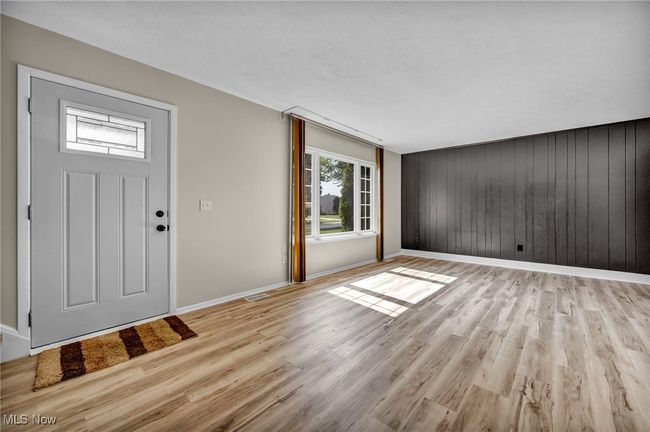 Entrance foyer with light wood-style floors and wooden walls | Image 26