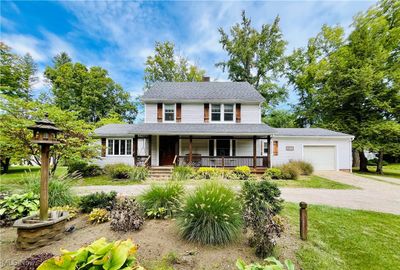 View of front of home with a porch and a​​‌​​​​‌​​‌‌​‌‌​​​‌‌​​‌‌​‌​​​​​‌ garage | Image 1