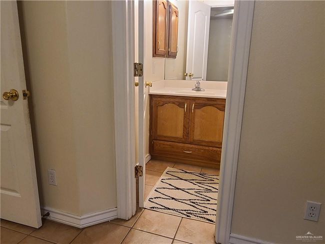Bathroom featuring tile patterned flooring, vanity, and baseboards | Image 9