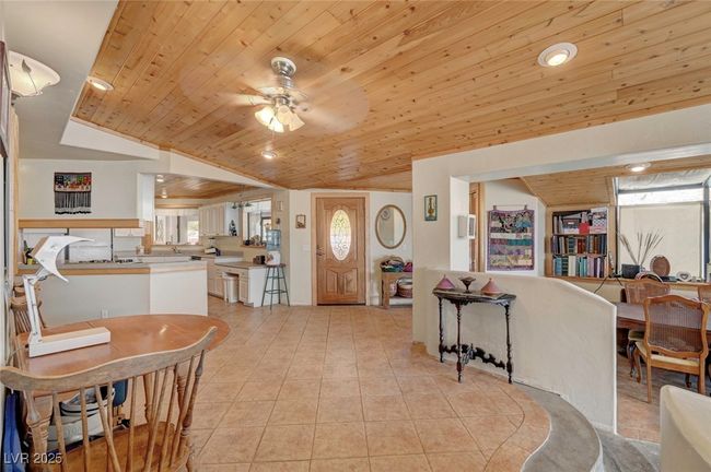 Living area featuring wooden ceiling, lofted ceiling, plenty of natural light, a ceiling fan, and light tile patterned flooring | Image 25