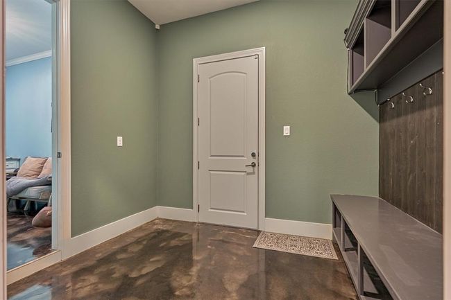The conveniently located mudroom, just off the garage and entry, features custom built-ins and hooks—perfect for organizing bags, shoes, and everyday essentials. | Image 12