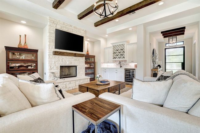 Living room that has a beverage bar and stone fireplace | Image 6