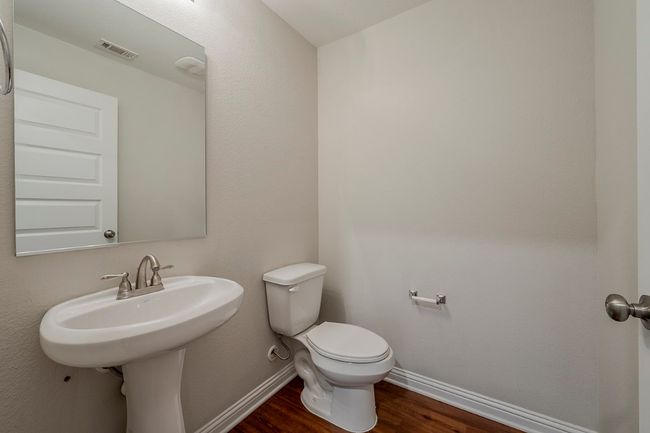 Bathroom featuring baseboards, toilet, wood finished floors, and visible vents | Image 22