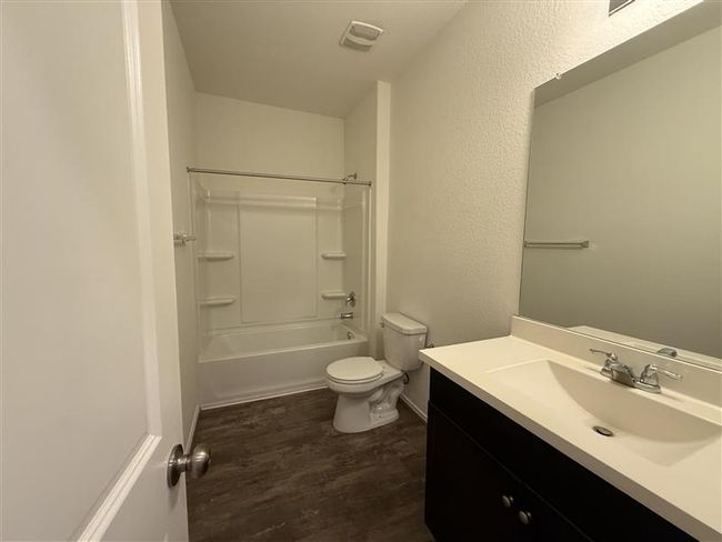 Full bathroom with vanity, toilet, wood finished floors, and shower / washtub combination | Image 12