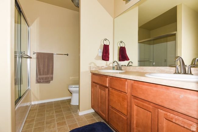 Bathroom featuring double vanity, a sink, toilet, and tile patterned flooring | Image 22