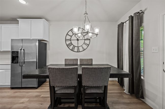 Dining space with a chandelier and light wood-style floors | Image 11