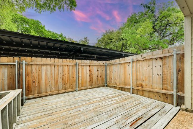 View of deck from back door. Carport with one reserved parking spot is just outside the gate. | Image 25