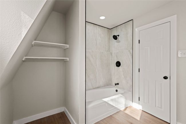 Full bathroom featuring baseboards, wood finished floors, and bathing tub / shower combination | Image 21