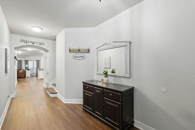 Hallway featuring arched walkways, dark wood-type flooring, and stairs | Image 11