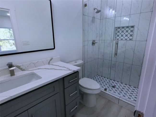 Bathroom with vanity, a shower stall, and toilet | Image 10