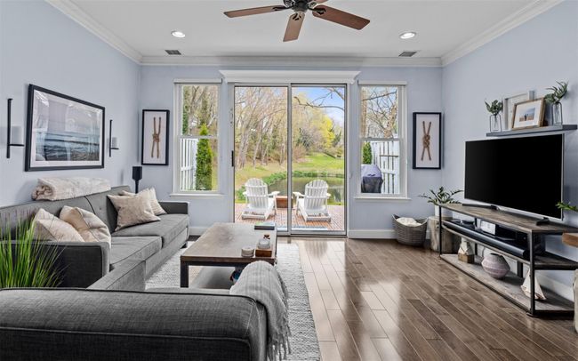 Living room featuring baseboards, wood finished floors, visible vents, and ceiling fan | Image 6