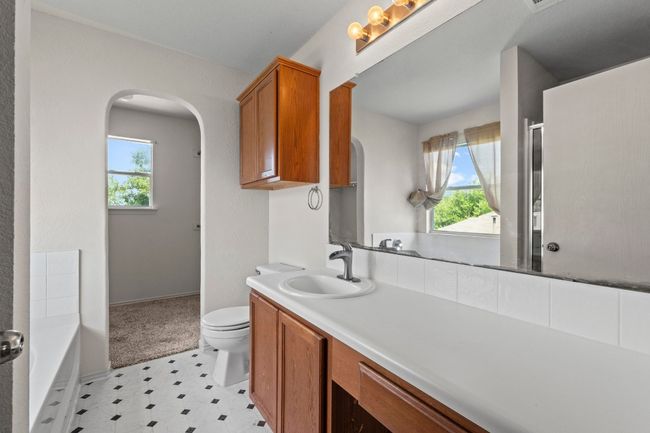 The en-suite bathroom contains a long vanity and lots of cabinet space for linens and/or bathroom needs. | Image 17