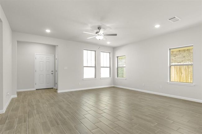 Empty room featuring baseboards, recessed lighting, a ceiling fan, visible vents, and wood finished floors | Image 9