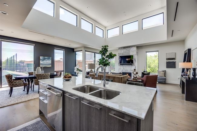 Kitchen with light wood-style floors, dishwasher, open floor plan, and a sink | Image 12