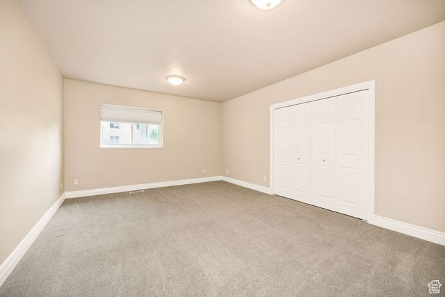 Unfurnished bedroom with carpet flooring, baseboards, and a closet | Image 31