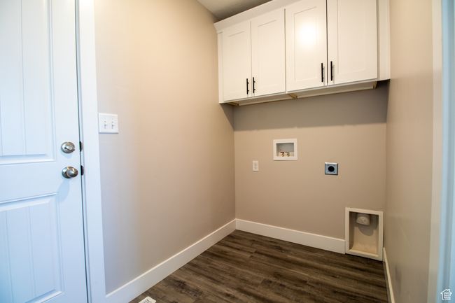 Clothes washing area with hookup for a washing machine, electric dryer hookup, cabinet space, baseboards, and dark wood-type flooring. *Photo in picture is similar to the home being built | Image 9