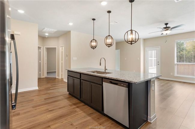 Kitchen with appliances with stainless steel finishes, ceiling fan, light wood finished floors, a kitchen island with sink, and recessed lighting | Image 8