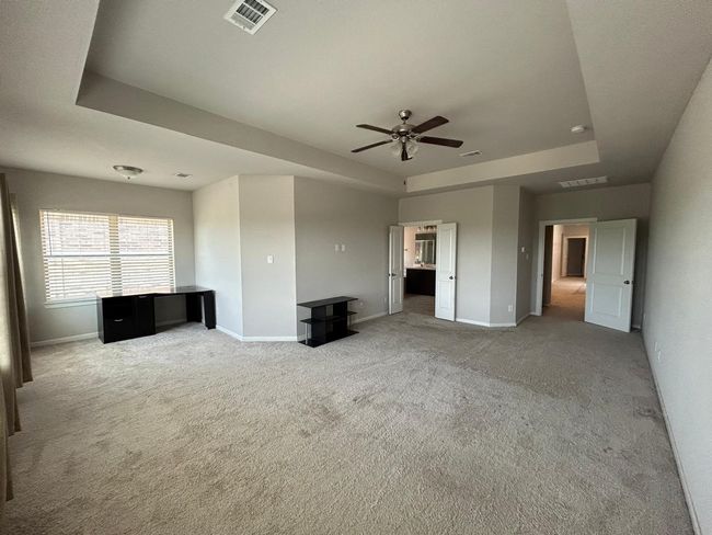 Unfurnished living room with a raised ceiling, carpet flooring, baseboards, and a ceiling fan | Image 25