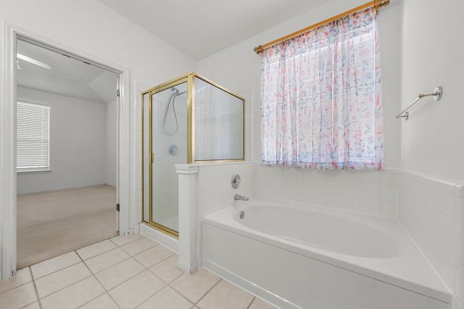 Bathroom with a garden tub, a shower stall, and tile patterned flooring | Image 13