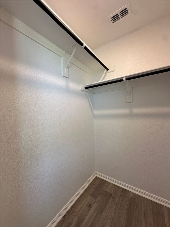 Walk in closet with visible vents and dark wood-style floors | Image 16