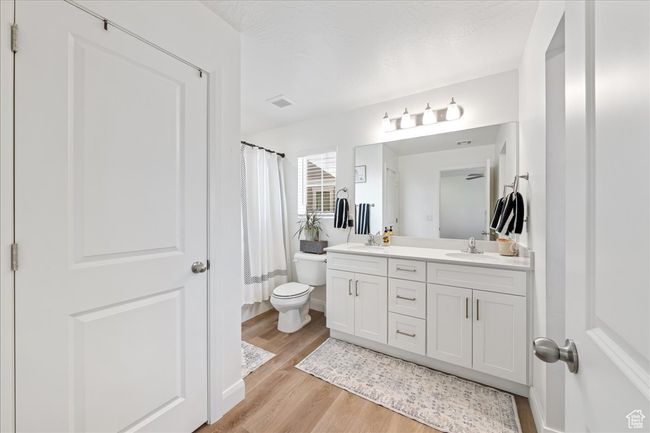 Bathroom with double vanity, wood finished floors, and a shower with shower curtain | Image 21
