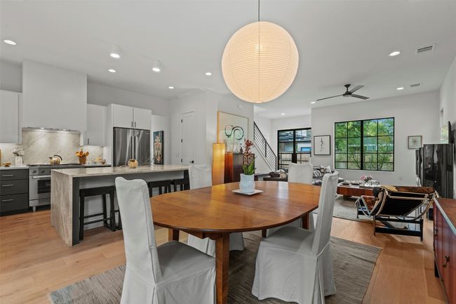 Kitchen featuring stainless steel appliances, light stone counters, light wood-style floors, a breakfast bar, and recessed lighting | Image 14
