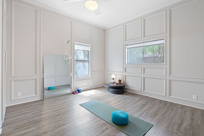 Exercise room with a decorative wall, plenty of natural light, ceiling fan, and light wood finished floors | Image 25