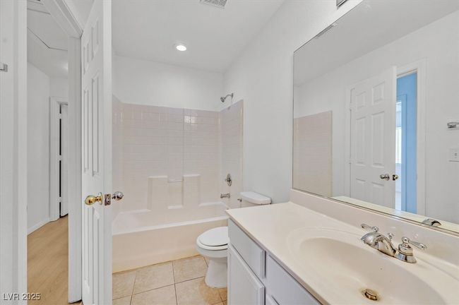 Bathroom with vanity, shower / bathtub combination, and tile patterned flooring | Image 17