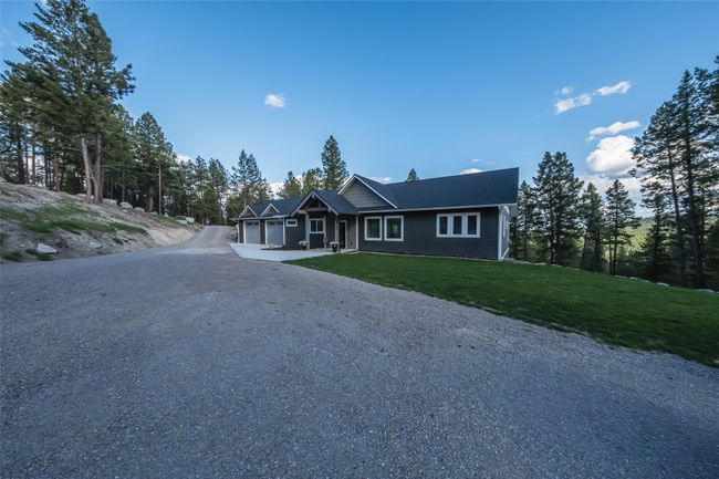 Single story home with an attached garage, gravel driveway, and a front lawn | Image 51