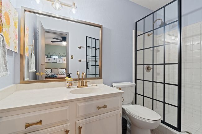 Bathroom featuring ceiling fan, a shower stall, vanity, toilet, and ensuite bath | Image 5