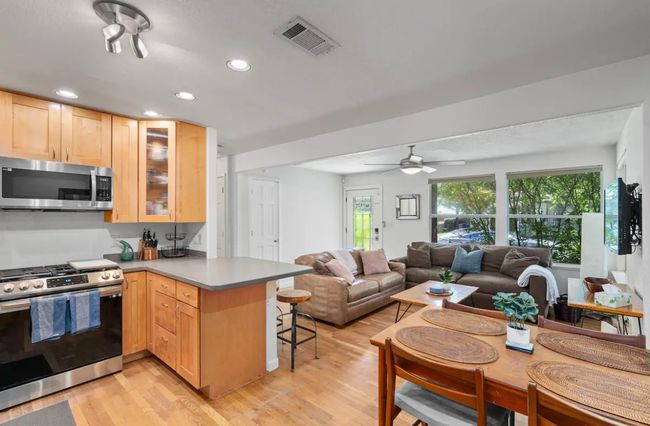 Kitchen featuring stainless steel appliances, a peninsula, light brown cabinetry, a breakfast bar area, and open floor plan | Image 11