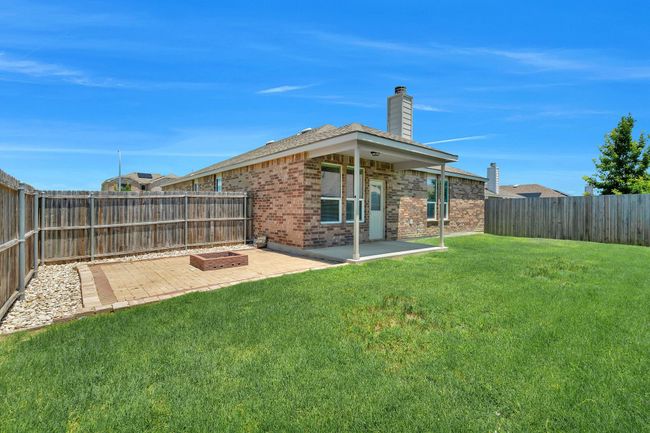 Fenced backyard with a patio | Image 26