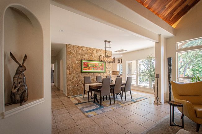 Tiled dining room with plenty of natural light, a chandelier, wood ceiling, and baseboards | Image 10