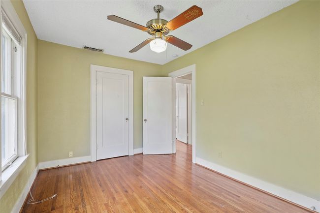 Unfurnished bedroom featuring wood finished floors, baseboards, a ceiling fan, and a closet | Image 9