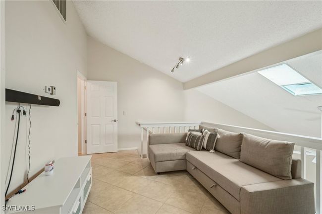 Living room featuring a skylight, lofted ceiling, and light tile patterned flooring | Image 23