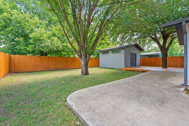 Fenced backyard featuring an outbuilding and a patio area | Image 19