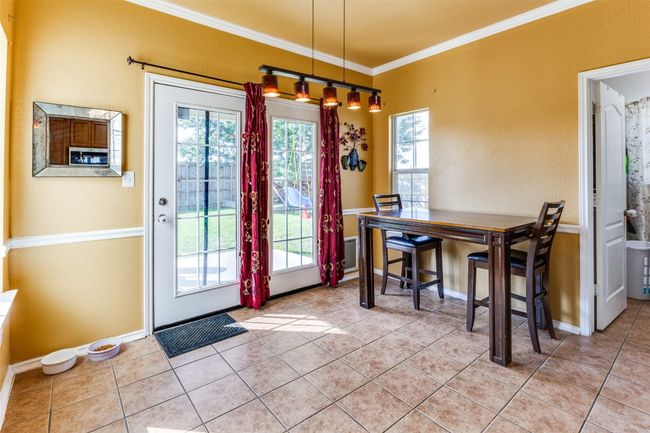 Dining room with ornamental molding, plenty of natural light, light tile patterned floors, and baseboards | Image 14