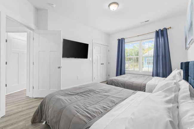 Bedroom with wood finished floors and visible vents | Image 20