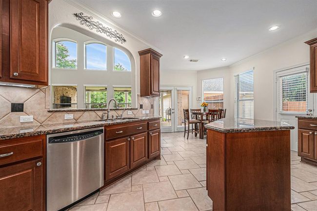 The sink is conveniently placed under an arch offering views of the family room and outdoor spaces! | Image 13