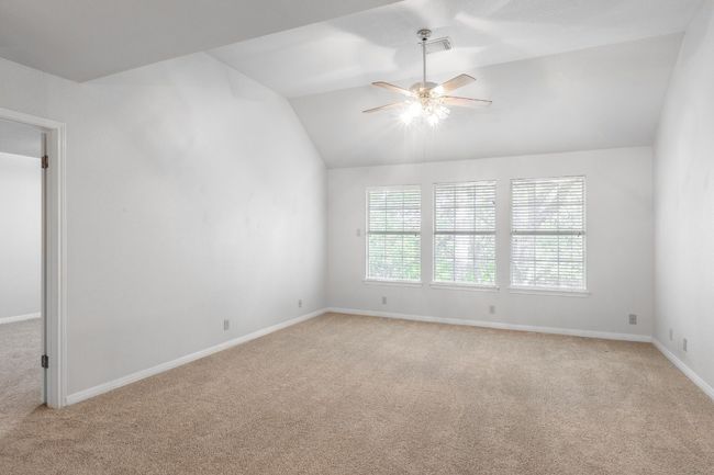 Spare room with light colored carpet, ceiling fan, lofted ceiling, and baseboards | Image 23